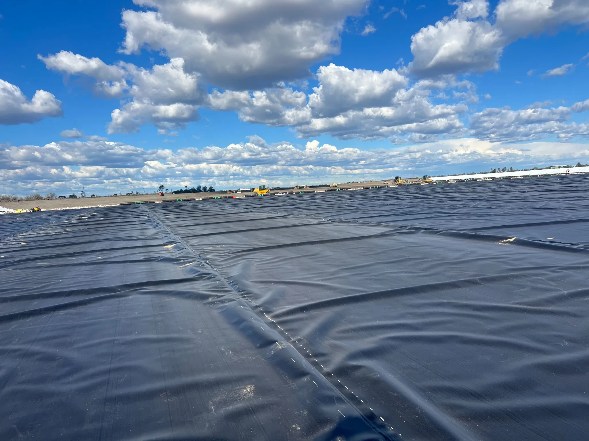 Large-scale HDPE liner installation covering an extensive containment footprint